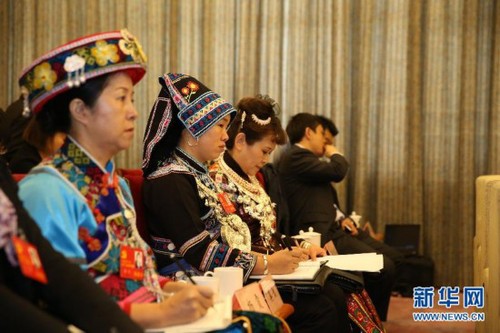 During the 18th CPC National Congress, delegates wearing traditional ethnic minority costumes attend the panel discussion of delegates from southwest China's Guizhou Province on November 10, 2012. [Xinhua]