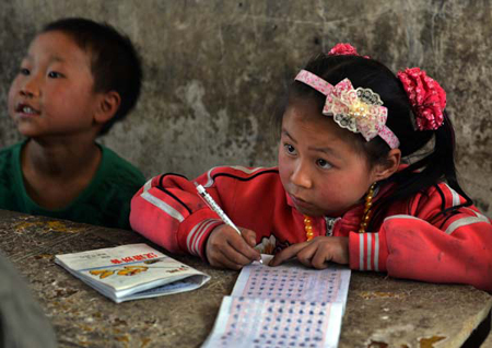 A girl attends a class at a rural school in Bijie, Guizhou Province. China's education authority said the country will make more efforts to improve fairness in education. [China Daily/ Peng Nian] 