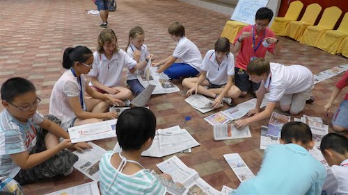 Children recycle old newspapers at the Bluestar International Summer Camp. [Women of China/Yao Yao]