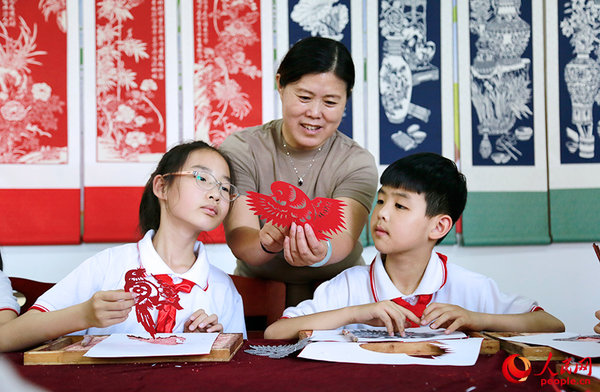 Inheritor Passes on Traditional Paper Cutting in N China's Tianjin